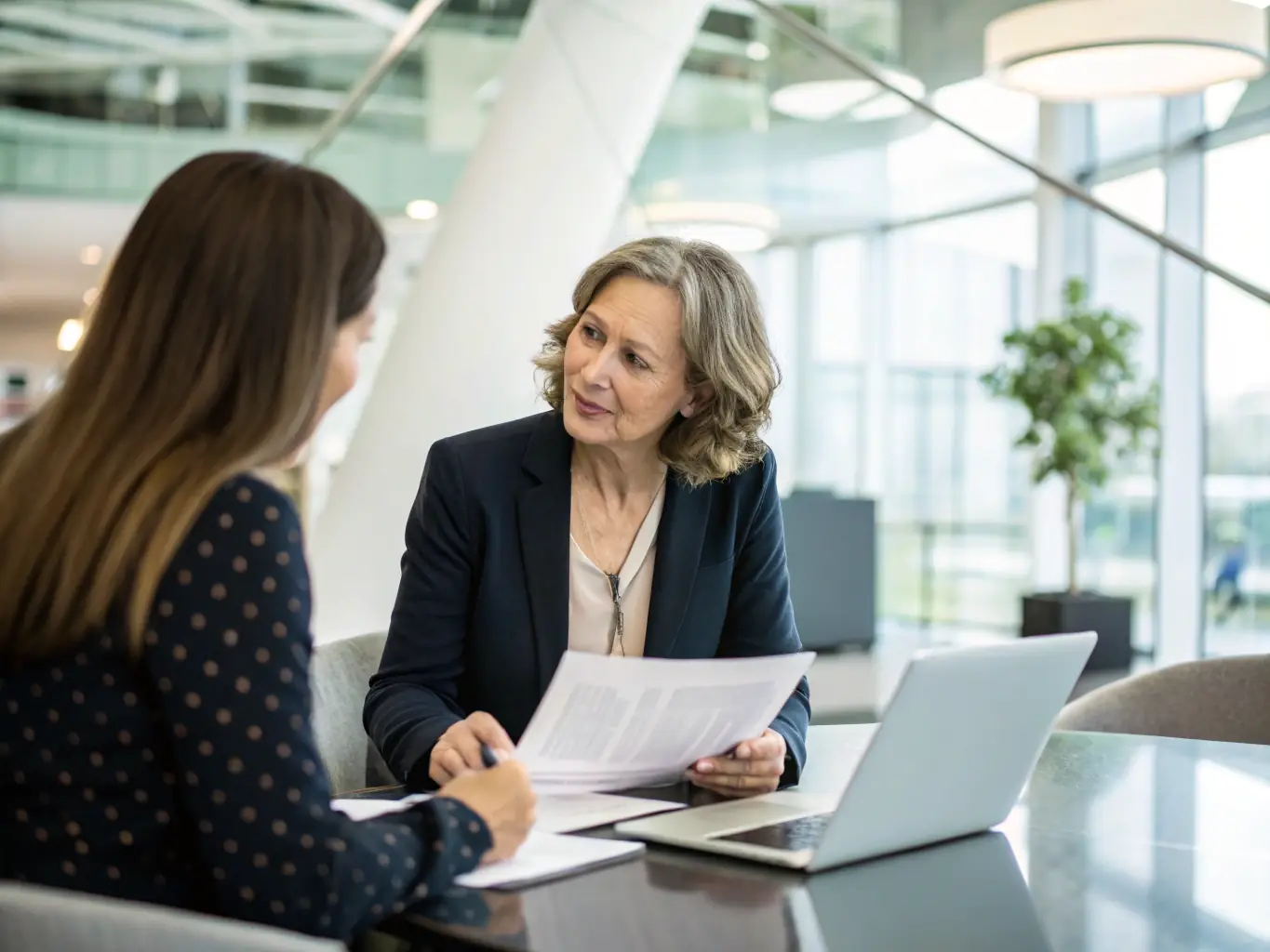 An image of a business coach in a one-on-one session with a client, reviewing financial reports and discussing performance metrics, illustrating the personalized and data-driven approach of MentorUKUno's coaching services.